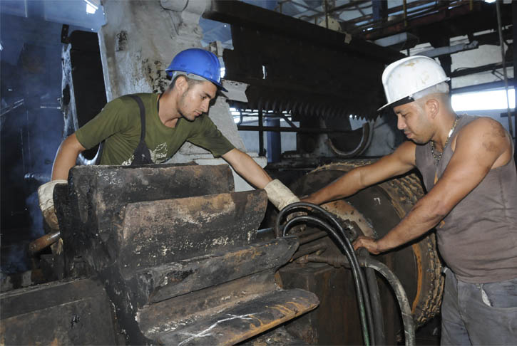 De izquierda a derecha Yasmany Arias Leyva y Carlos Manuel Hernández Mejías, asistentes de mecánicos en el central 14 de Julio. / Fotos Dorado.