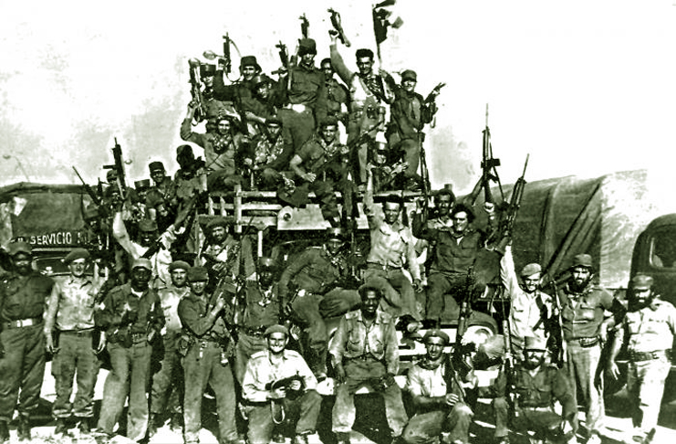 Milicianos levantan sus armas en señal de victoria sobre la fuerza mercenaria financiada por Estados Unidos. /Foto: Archivo Granma