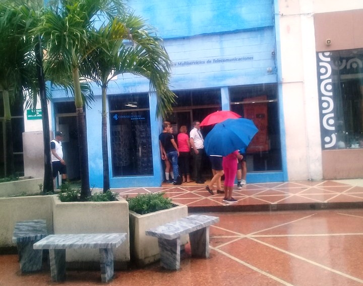 En la puerta del Centro Multiservicios de Etecsa, nuestros vecinos en el Bulevar, unas seis personas se empaparon con un aguacero, de los que a intervalos sobrepasaron los 100 mm de lluvia en días pasados./Foto: Magalys Chaviano