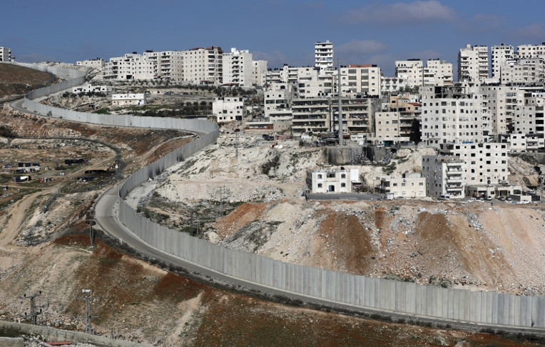 Polémica barrera de separación de Israel dividiendo Jerusalén oriental (I) de la aldea de Cisjordania de Anata (D). /Foto: Thomas Coex (AFP)