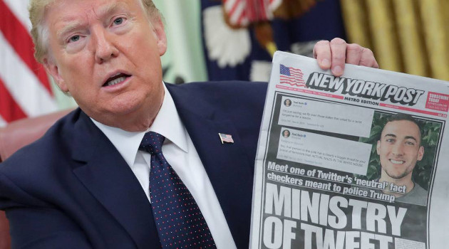 Trump muestra la portada del New York Post que se hace eco del diferendop con Twitter. /Foto: Jonathan Ernst (Reuters)