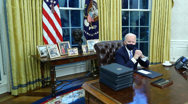 Joe Biden firma órdenes ejecutivas en la Oficina Oval de la Casa Blanca en Washington (EE.UU.), el 20 de enero de 2021. /Foto: Tom Brenner / Reuters