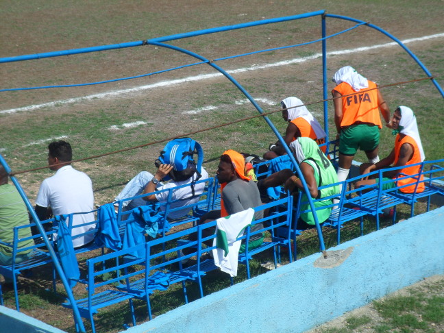 Con cualquier cosa se protegieron del implacable sol los jugadores de ambas bancas, pues lo impensable sucedió: no tenemos techo para ellas. /Foto: Carlos E. Chaviano