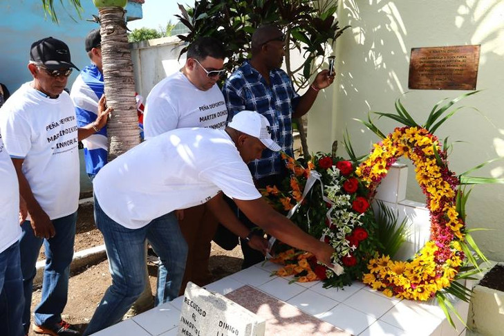 Peñistas de la "Martín Dihigo" colocan ofrendas florales en la modesta tumba de la necrópolis de Cruces que guarda los restos del más grande pelotero cubano de todas las épocas. /Foto: Aslam Castellón