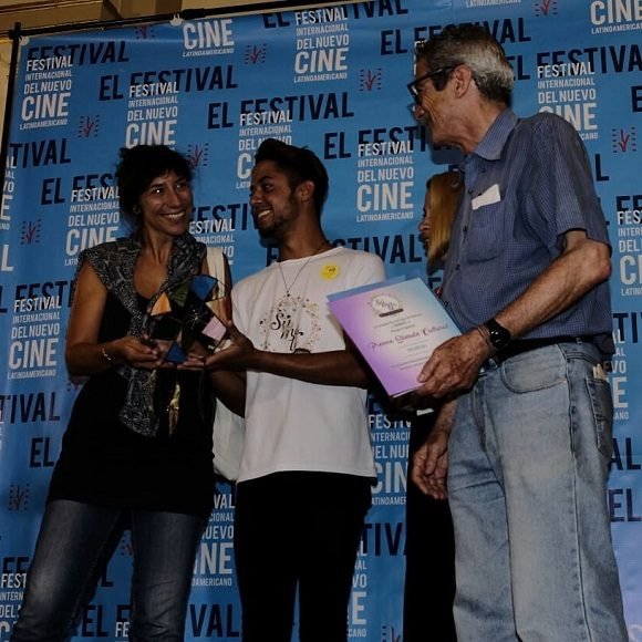 El director de cine cubano, Fernando Pérez, recoge un premios colateral ganado por “Insumisas. Foto: @festivaldecinedelahabana/ Facebook.