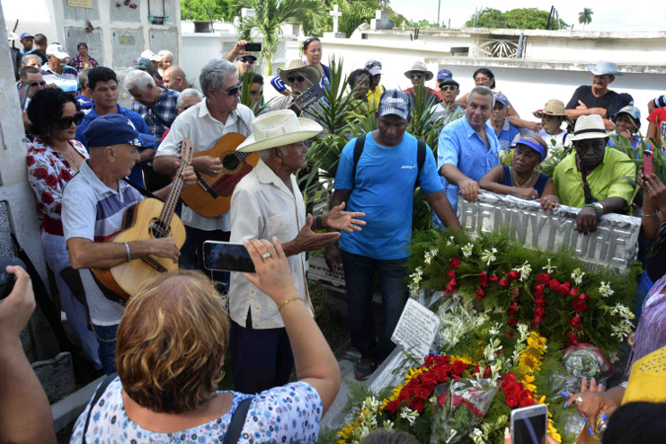 Flores y canciones en torno a la losa que guarda los restos del Benny, pero no atrapa la voz eterna del Sonero Mayor. /Foto: Modesto Gutiérrez Cabo (ACN)