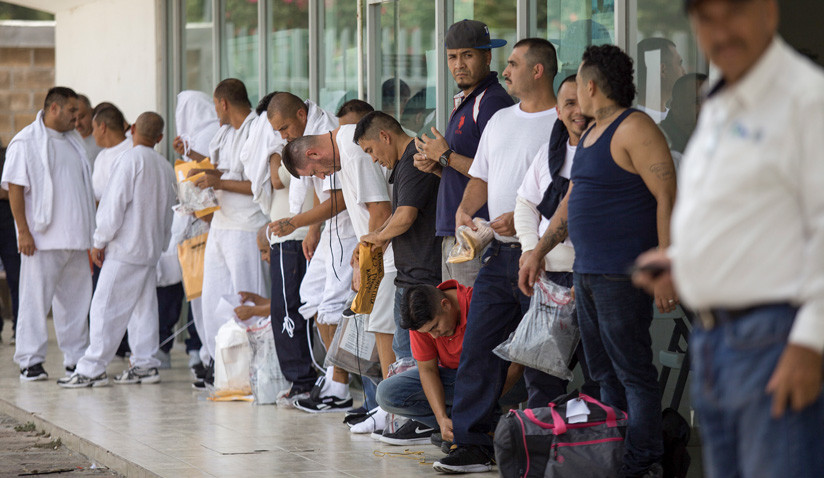 Migrantes esperan en la fila después de ser deportados por el gobierno de EE.UU. a la entrada del puente internacional de la ciudad de Matamoros, Tamaulipas, el 22 de julio de 2019. / Carlos Ogaz / AFP
