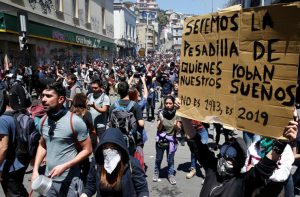 Vivienda, salud, pensiones, educación y agua son algunos de los reclamos históricos, que hoy vuelven a aflorar en Chile, y dejar en evidencia las profundas grietas de la desigualdad. Una persona sostiene un cartel durante una protesta en Valparaíso, Chile, 21 de octubre de 2019. /Foto: Rodrigo Garrido (Reuters)