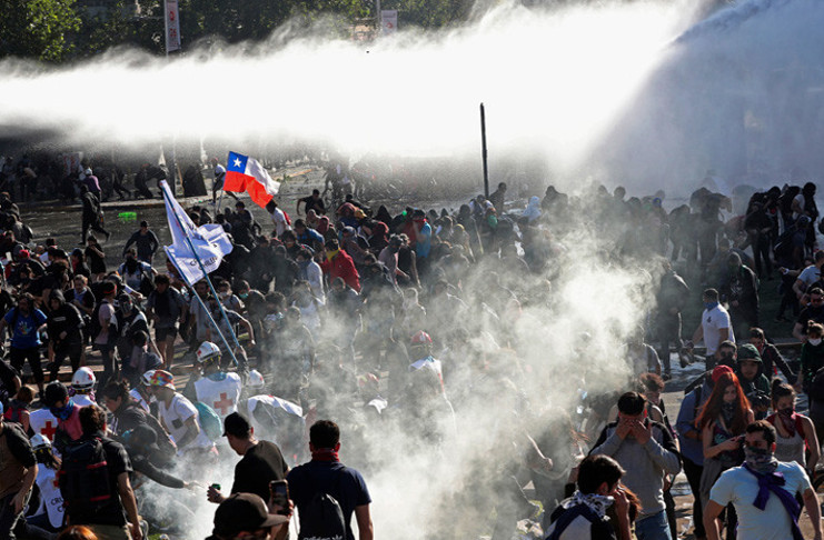Las fuerzas de seguridad lanzan agua y gases lacrimógenos en Santiago de Chile, el 20 de octubre de 2019. /Foto: Esteban Félix (AP)