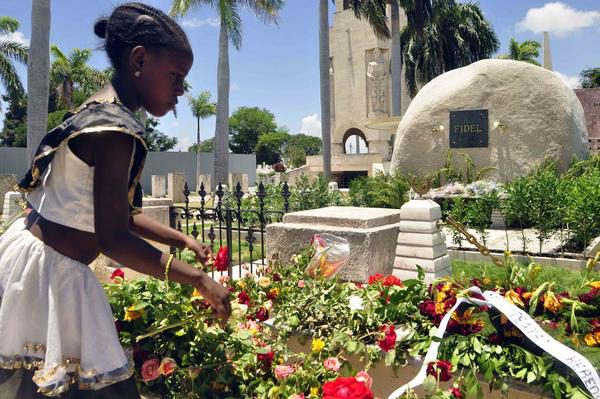 Niña deposita flores al Comandante en Jefe Fidel Castro Ruz en el monolito donde descansan sus resto en el cementerio Santa Ifigenia, en Santiago de Cuba. /Foto: Miguel Rubiera Justiz (ACN)
