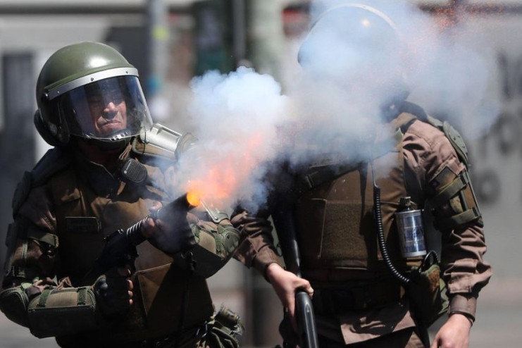 Efectivos antimotines del cuerpo de Carabineros lanzan bombas lacrimógenas a los manifestantes durante choques en Valparaíso, Chile, el 23 de octubre. /Foto: Fernando Bizerra Jr. (EFE)