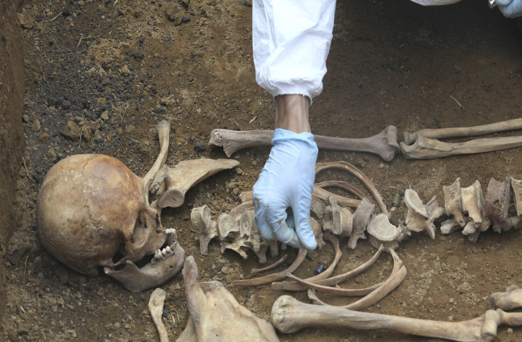 Un geólogo forense coloca una bala entre los huesos de un esqueleto humano en una fosa común en Mosquera. 19 de junio de 2013. /Foto: Jose Miguel Gomez (Reuters)