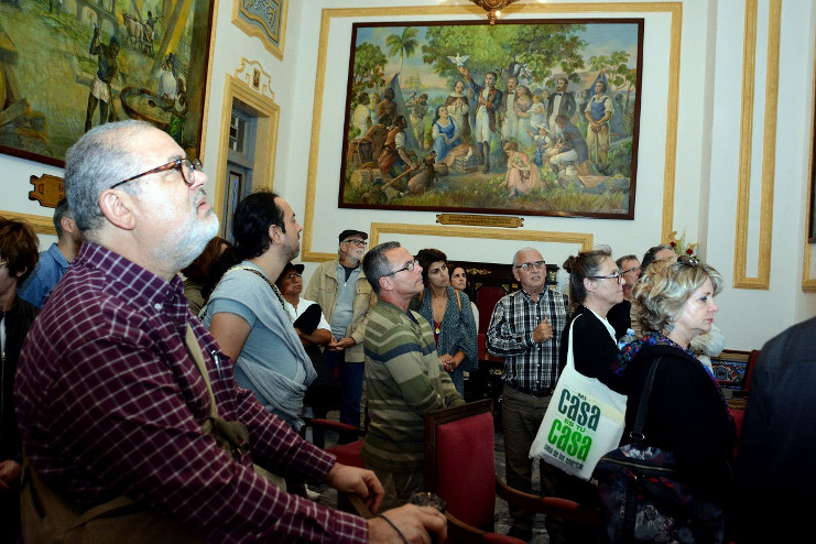 Admiran obras de pintores locales y foráneos sobre la historia cienfueguera que adornan el Salón de Protocolo del Gobierno. /Foto: Modesto Gutiérrez Cabo (ACN)