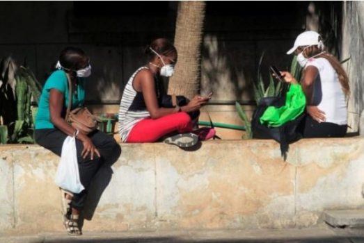 Las personas usan sus teléfonos móviles con máscaras protectoras en medio de las preocupaciones sobre la propagación del brote de coronavirus, en La Habana, Cuba, el 19 de marzo de 2020. Foto: Reuters / Stringer