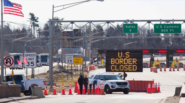 Agentes policiales de EE.UU. apostados cerca de la frontera con Canadá junto a un letrero que reza que la frontera está cerrada. 22 de marzo de 2020. /Foto: AFP