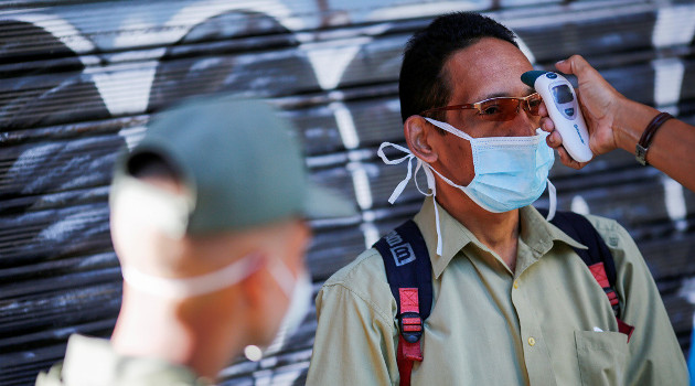 Un miembro de la Guardia Nacional Bolivariana mide la temperatura corporal en un mercado público en Caracas, Venezuela, 18 de marzo de 2020./Foto: Manaure Quintero (Reuters)