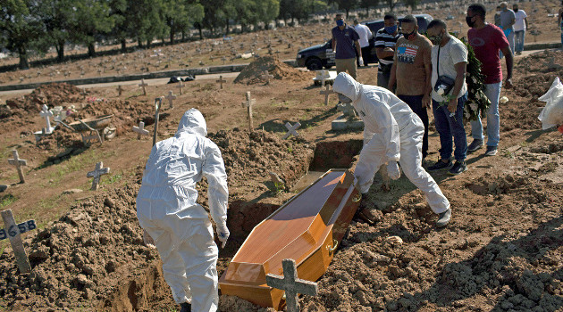 Trabajadores con equipo de protección realizan exhumación en el cementerio de Caju en Río de Janeiro, Brasil. 20 de mayo de 2020. /Foto: Silvia Izquierdo (AP)