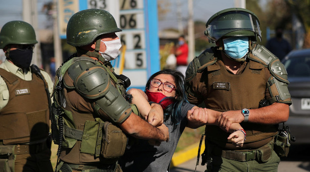 Una mujer es detenida después de gritar consignas contra la policía antidisturbios en un barrio pobre de la comuna El Bosque, en Santiago, Chile 18 de mayo de 2020. /Foto: Ivan Alvarado (Reuters)