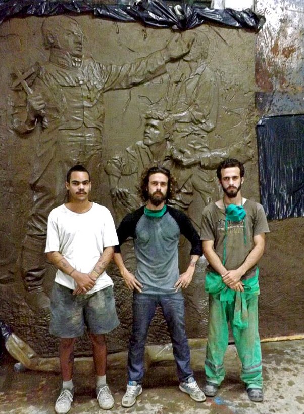De izquierda a derecha, Mario Velázquez Triana, José Carlos Beltrán Labrada y su hermano Pedro Enrique frente a una parte de lo que será el mural que recoge el momento de fundación de la Colonia de Fernandina de Jagua. / Foto: Igorra