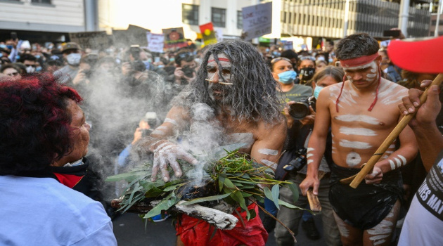 Manifestantes participan en una ceremonia tradicional aborigen, durante la marcha contra el racismo en Sídney, el 6 de junio de 2020. /Foto: Saeed Khan (AFP)