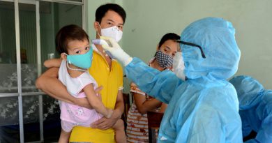 Un trabajador sanitario mide la temperatura de habitantes de la ciudad vietnamita de Da Nang, 26 de julio de 2020. /Foto: Quoc Dung (VNA / Reuters)