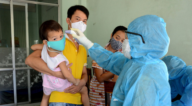 Un trabajador sanitario mide la temperatura de habitantes de la ciudad vietnamita de Da Nang, 26 de julio de 2020. /Foto: Quoc Dung (VNA / Reuters)