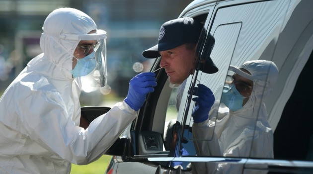 Trabajador sanitario con indumentaria protectora toma una muestra de mucosa para realizar una prueba de detección del coronavirus, el 30 de julio de 2020 en un área de servicio próxima a Ruhpolding, al sur de Alemania. /Foto: Christof Stache (AFP)