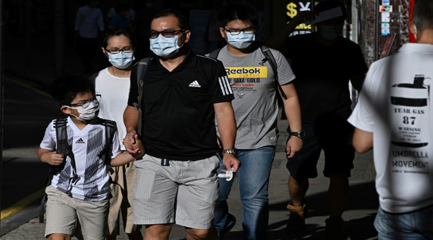 Varios peatones con mascarilla caminan por una calle de Hong Kong, el 27 de julio de 2020 en esa ciudad china donde se implantó el uso obligatorio del accesorio. /Foto: Anthony Wallace (AFP)