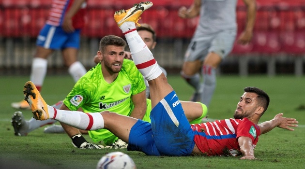 El portero del Athletic de Bilbao Unai Simon y el centrocampista francés del Granada Maxime Gonalons, protagonizan una incidencia de juego durante el partido de la fecha inaugural de La Liga española, el 12 de septiembre de 2020 en Granada. /Foto: Jorge Guerrero (AFP)