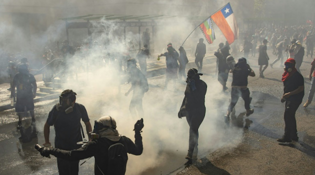 Manifestantes se enfrentan a carabineros en el centro de Santiago el 18 de octubre de 2020. /Foto: Martín Bernetti (AFP)