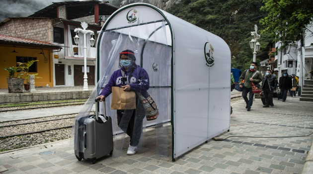 Un visitante atraviesa una cámara de desinfección en Aguas Calientes, en su camino hacia el sitio arqueológico de Machu Picchu, en Cusco, Perú. /Foto: Ernesto Benavides (AFP)