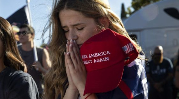 Una muchacha de la ciudad de Oregon reza durante una manifestación en apoyo de Trump.