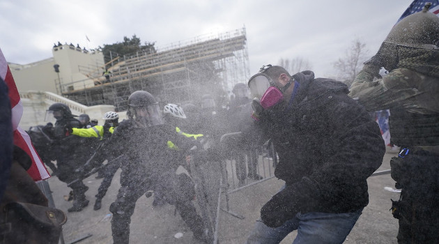 Simpatizantes de Donald Trump tratan de cruzar por la fuerza un cordón policial que rodea el Capitolio en Washington, 6 de enero de 2021. /Foto: Julio Cortez / AP