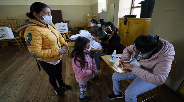 Una niña acompaña a una mujer a votar en un centro electoral en Quito (Ecuador). Los colegios electorales abrieron hoy a las 07.00 hora local, en unos comicios marcados por la pandemia de coronavirus. /Foto: José Jácome / EFE