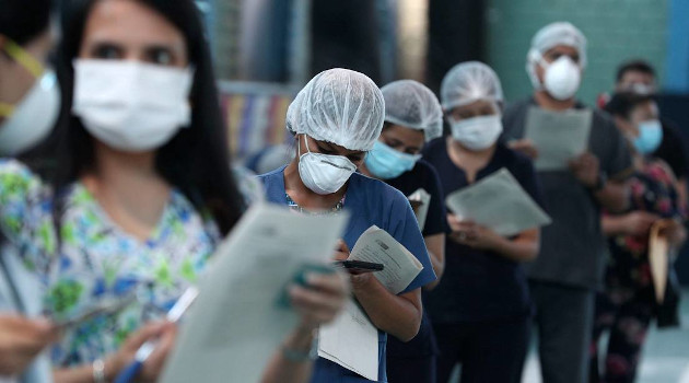 Enfermeros y médicas esperan en la fila para recibir una inyección de la vacuna Sinopharm de China. Lima, 10 de febrero de 2021. /Foto: Martin Mejia / AP