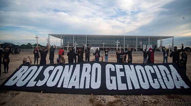 Manifestantes extienden una pancarta en la capitalina Plaza de los Tres Poderes contra Bolsonaro, a quien también califican de genocida. Por ello fueron detenidos. /Foto: PL