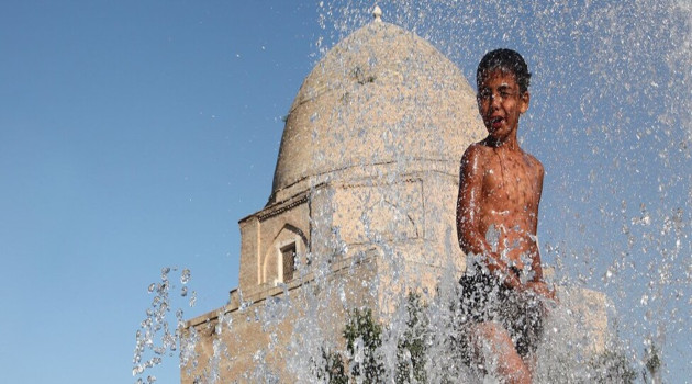 Un niño se refugia del calor en una fuente de la ciudad de Samarcanda, en Uzbekistán/Foto: Unicef
