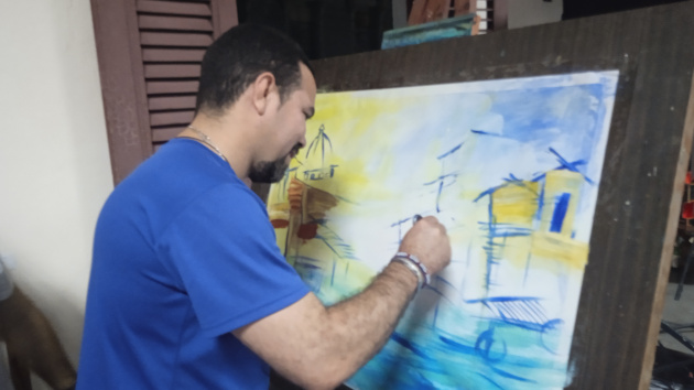 Yasel Toledo Garnache, presidente nacional de la Asociación Hermanos Saíz deja su huella en la obra artística de Pepe Saborido. / Foto: del autor