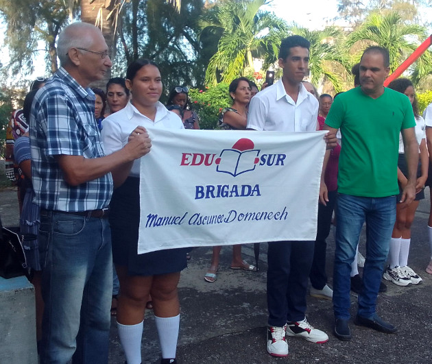 Entregan Lionel Meneses, director general de Educación Provincial, y Maikel Betancourt, miembro del Buro Provincial del PCC, la bandera a los estudiantes de la escuela pedagógica.